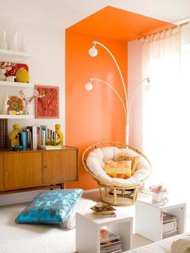 Sala com cantinho decorado com uma faixa laranja pintada na parede.