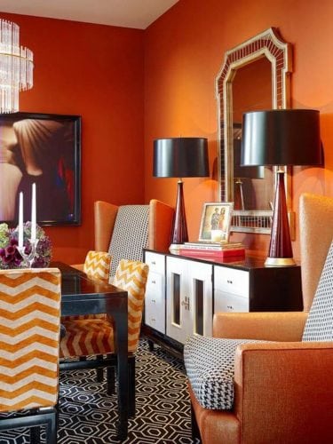 Sala de jantar com as paredes pintadas de laranja.