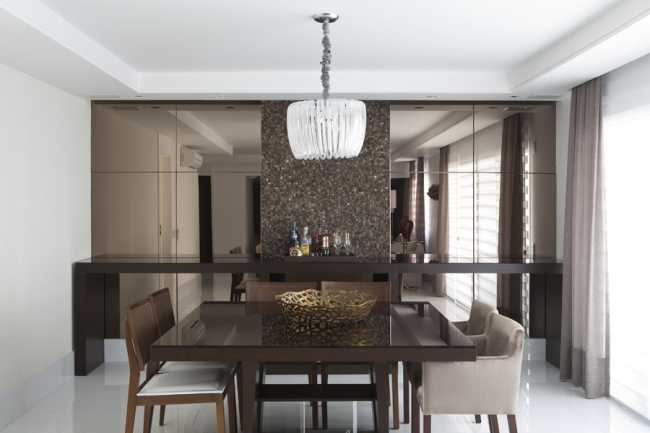 Sala de jantar com duas faixas de espelhos na cor bronze .