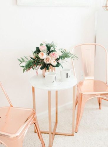 Rose Gold ou cobre na decoração, cadeiras em rose gold e mesa tampo em vidro branco e pés em rose gold.