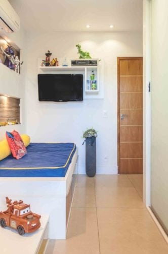 Apartamento otimizado, quarto de menino com tv na parede e na lateral da cama.