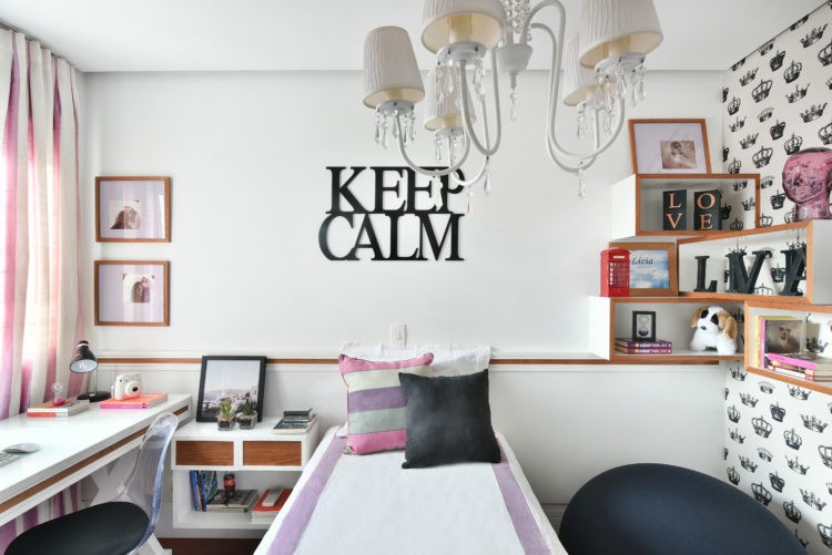 Quarto de adolescente rosa e preto na decoração, e em cima da cama em escultura em madeira pintada de preto, escrito em ingles keep calm
