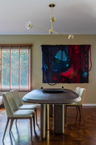 Sala de jantar decorada com uma tapeçaria na parede
