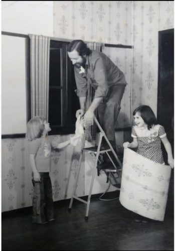 Catia Badia com seu irmão ajudando ao pai colocar um papel de parede.