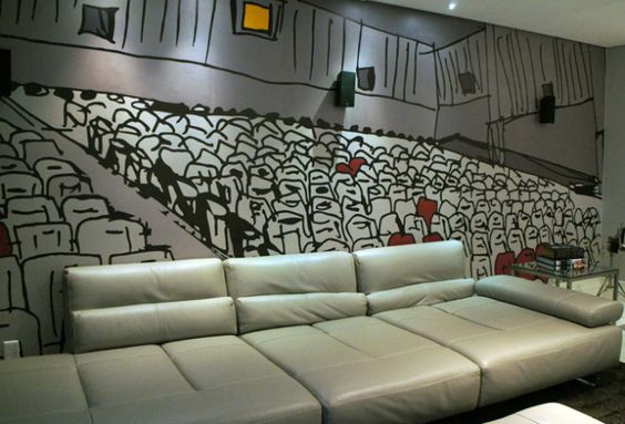 Sofá confortável para assistir filmes e decoração da sala com o papel imitando uma sala de cinema.