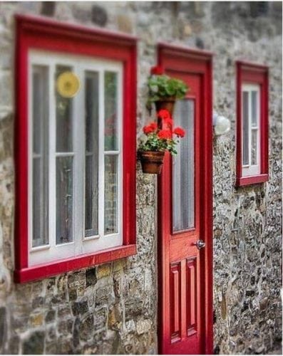 Portas de entradas coloridas. Porta e janela vermelha na fachada de pedras.