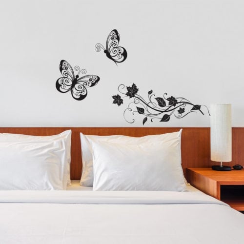 Adesivo de borboletas na cabeceira da cama.