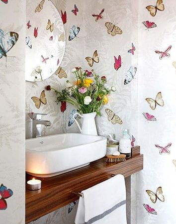 Lavabo decorado com papel de parede de borboletas.