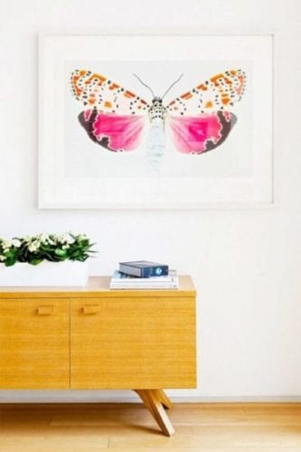 Quadro com borboleta rosa decorando a parede .