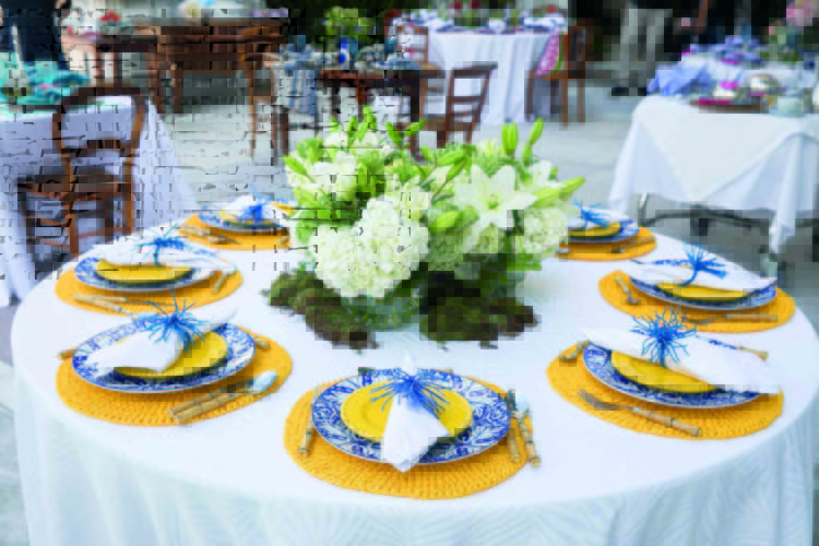 Inspirações para se criar mesas caprichadas, mesa redonda com arranjo de flor baixo e louça azul com jogo americano amarelo