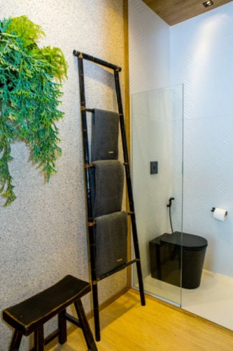Escada decorativa usada como toalheiro no banheiro. Espaço na Casa Cor Rio.