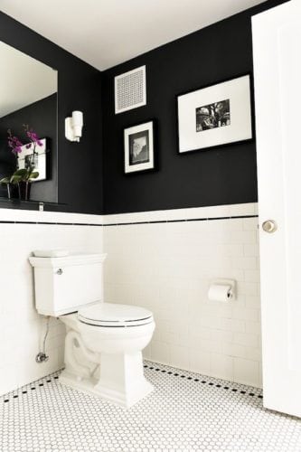Banheiro em preto e branco, com meia parede pintada de preto fosco.
