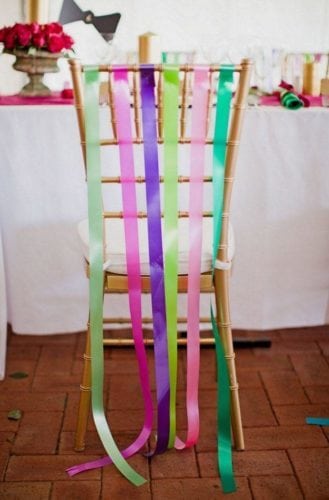 Ideias de decoração de Carnaval para festejar em casa.cadeira enfeitada com fitas coloridas nas costas