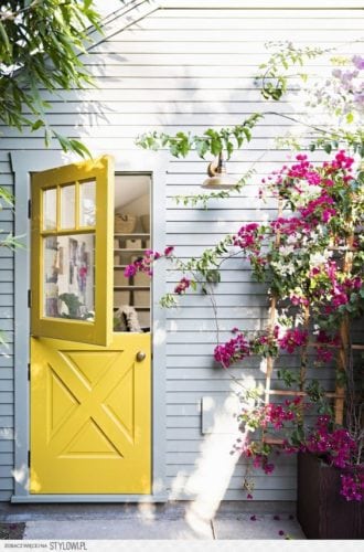 A porta holandesa também é chamada de "Dutch Door". Porta dividida ao meio, entrada do jardim pintada de cor amarela.