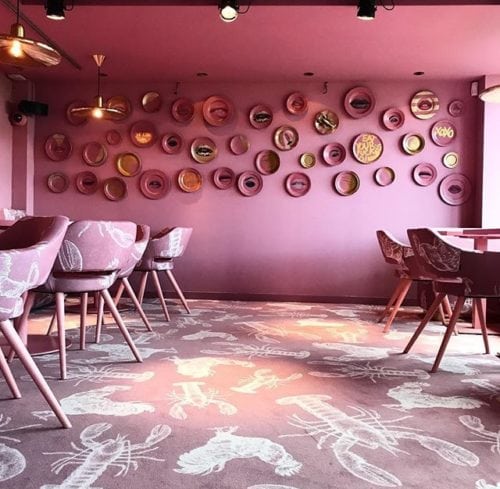 Restaurante MaMa kelly em Amsterdã decorado todo em Pink, carpete Rosa com estampa de frango e lagosta , especialidade da casa.