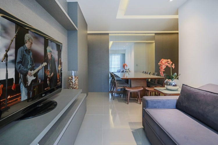 Com soluções de arquitetura, apartamento de 90m² ganha mais espaço e conforto. Sala estar e jantar integradas e um grande espelho no fundo.