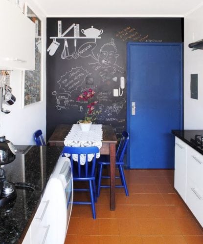 Inspirações para decorar usando lousa. Cozinha pequena, ganhou uma super bossa com a parede de fundo em lousa a porta azul contrastando.
