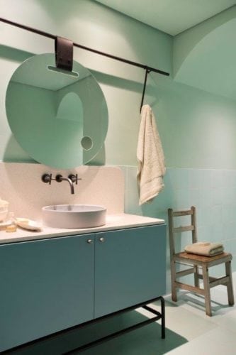 CASACOR SP: Ambiente Léo Shehtman, Casa dos arcos. Banheiro todo pintado em verde clarinho e espelho redondo na bancada.
