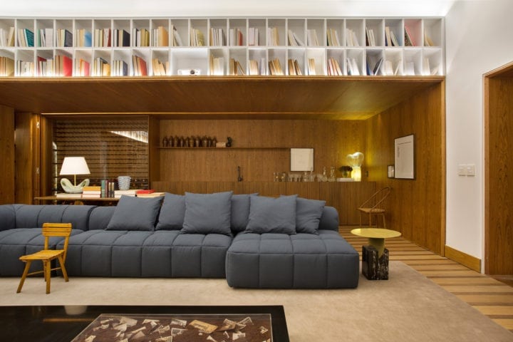 sofa e parede revestida de madeira de BC Arquitetos para casa cor sp
