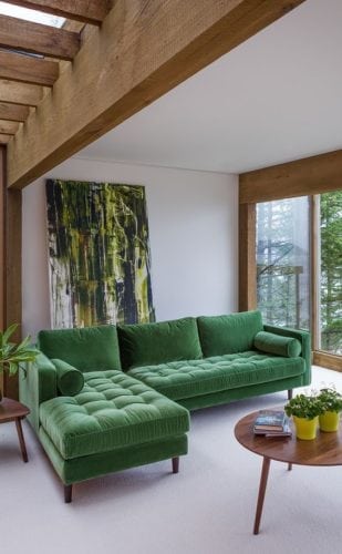 Decorando com os signos, a casa do Taurino. Sala com sofá verde e madeira no teto.