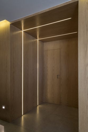 Entrada e projeto de iluminação do apartamento assinado por Ferrassa e Pickler