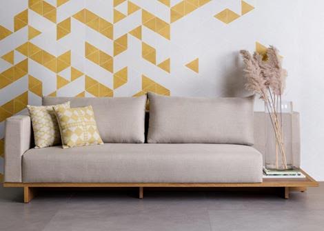 Obras de Candido Portinari foram inspiração para a criação de porcelanato. Salpicado em branco e amarelo na parede de fundo do sofá.