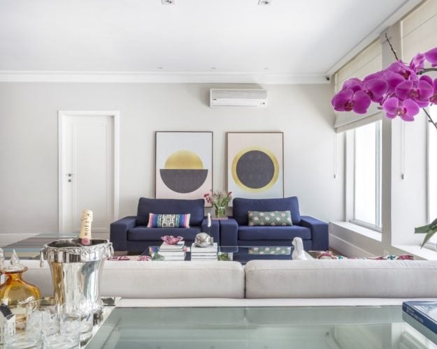 Sala de estar com poltronas azuis assinada por Triarq Studio Arquitetura