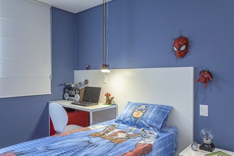 Quarto de menino decorado com o tema do homem aranha e parede pintada de azul.