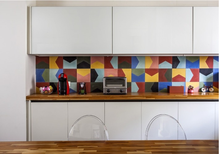 Urbanidade dá o tom para apartamento de família em SP. Destaque na cozinha, parede de funda da bancada de apoio revestida com azulejo hidráulico colorido.