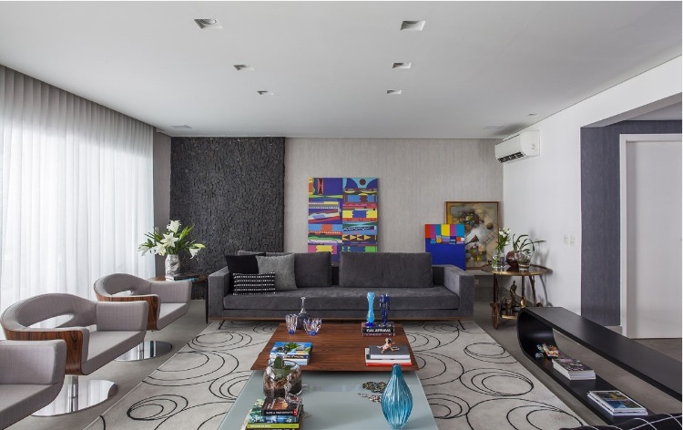 Urbanidade dá o tom para apartamento de família em SP. Living decorado em tons de cinza e uma tela colorida na parede.