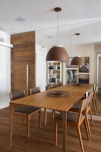 sala de jantar com mesa e porta de madeira no apto assinado por Bezamat Arquitetura
