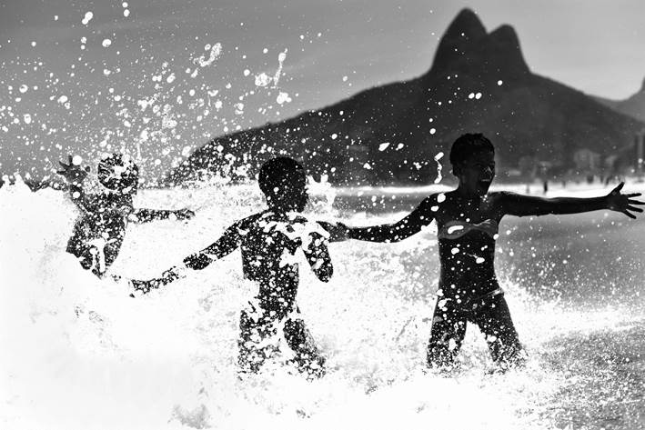crianças na praia em frente ao morro dois irmãos feita por ari kaye