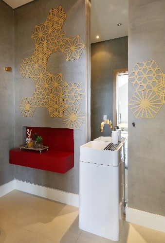 lavabo cinza com paineis vazados na parede no projeto da Triarq Arquitetura