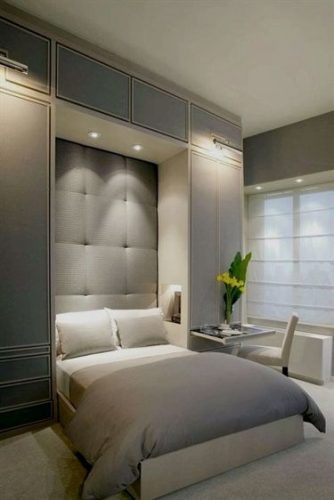 Decoração estilo clássico com cama embutido no armário, cabeceira acolchoada.