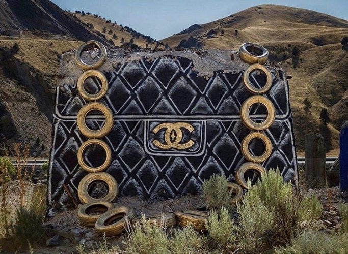 Grafiteiro americano, pinta em blocos de concreto abandonado, bosas de grife como Chanel por exemplo. Alça da bolsa foi feita de pneus pintados de dourado.