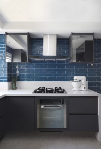 Spaço Interior assina projeto da casa nova da influenciadora Mari Saad. Cozinha com bancada em corian branco e revestimentos na cor azul.