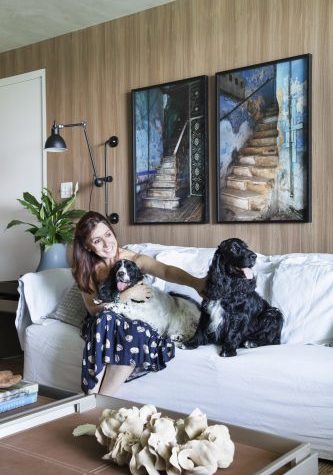 Carmen Mouro na sala com sofa branco e cachorros