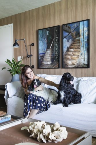 Carmen Mouro na sala com sofa branco e cachorros