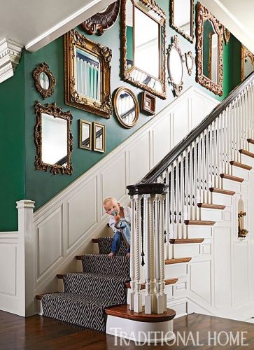 Decorando a parede da escada. Coleção de espelhos na parede verde .
