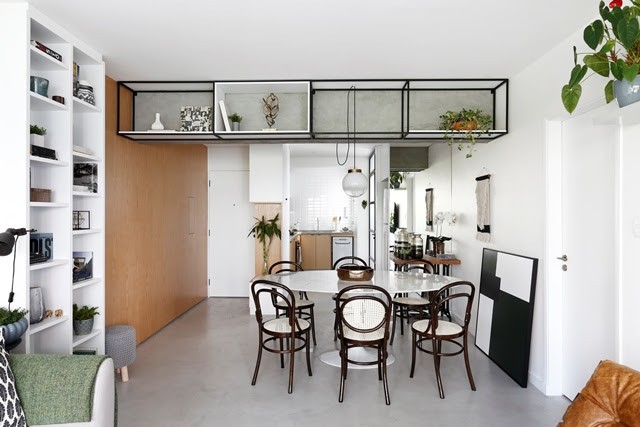 Apartamento de  95 m² e  40 anos ganha atmosfera moderna após reforma. Na viga, uma estante de ferro e a cozinha aberta para a sala.