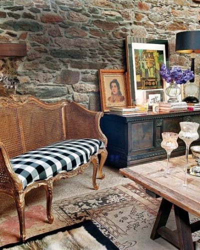 Xadrex na decoração. Ambiente com parede de pedra e sofá em palhinha com tecido xadrez