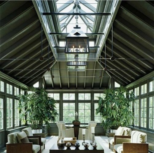Decór Naturalista: Verde que te quero verde. Sala com arquitetura integrada ao exterior, toda a estrutura verde com grandes janelas que tem verde ao redor e uma claraboia grande no teto.