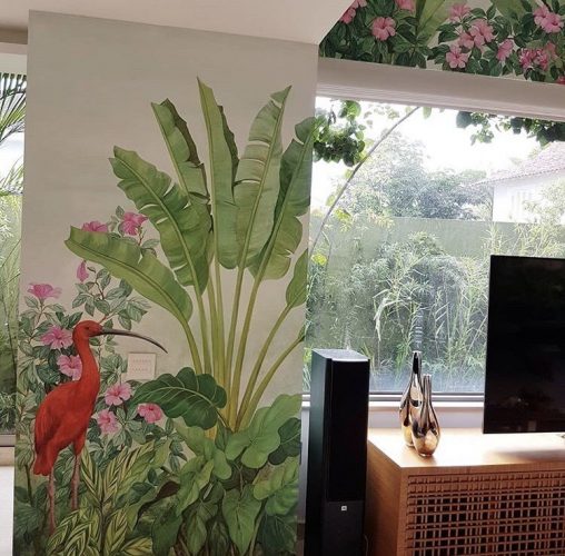 Decór Naturalista: Verde que te quero verde. Sala com janelão para a piscina , tendo a parede com uma pintura feita á mão . Pintura de palmeira e uma garça rosa.