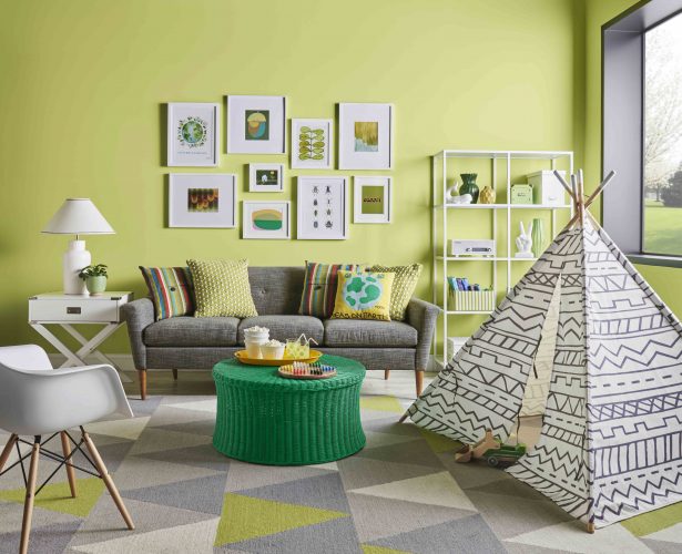 Verde cítrico é a cor do mês de agosto da Sherwin-Williams. Sala com sofá cinza e a parede de fundo do sofá com quadros e parede pintada com verde cítrico
