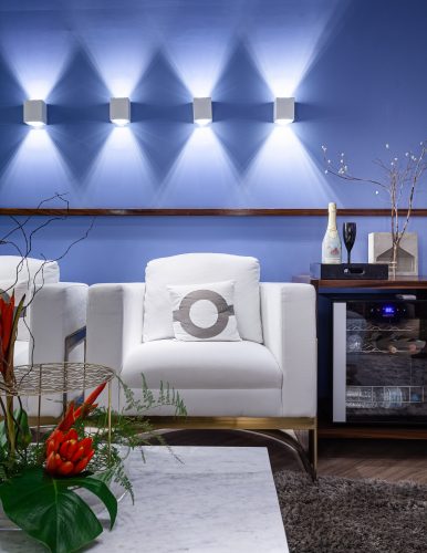 Feng Shui na sala zen, parede azul com luminárias e poltrona branca 