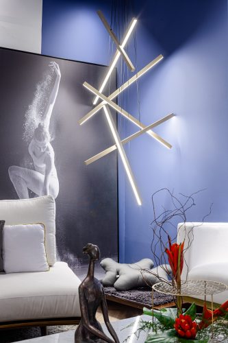 Sala zen, luminária de metal criando  uma escultura, tapete para cachorro embaixo e ao fundo parede azul