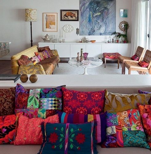 Misturas de estampas na decoração, sofá repleto de almofadas diferentes.