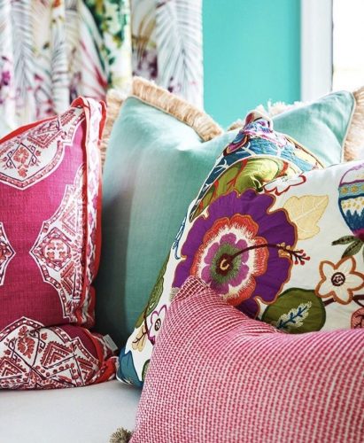 Mistura de estampas na decoração, almofadas estampadas com a cor vermelha em comum.