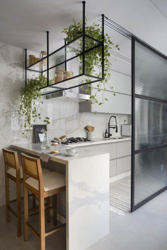 cozinha aberta com divisórias e armário suspenso com perfis preto no projeto de Beta Arquitetura