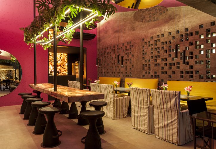 David Bastos assina restaurante Amado na CASACOR Bahia 2019, cobogós em uma parede e as restantes pintadas de rosa e espelhos redondos no teto.